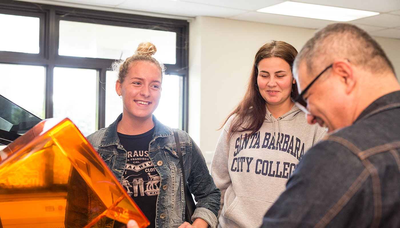 SBCC professor showing two students how to use a 3D Printer.